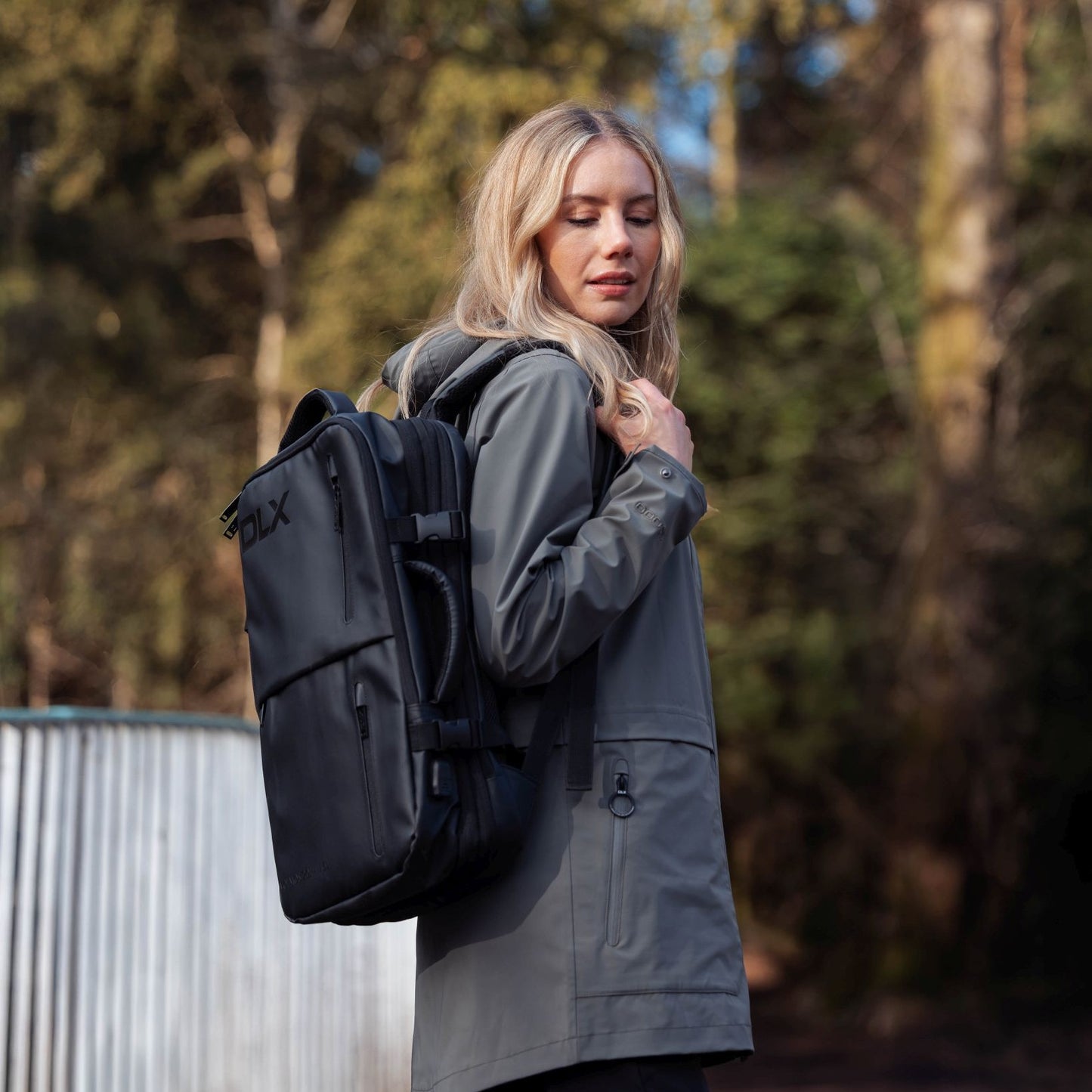 Woman wearing a black backpack with a blurred natural background