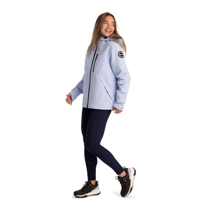 Side View of a Woman wearing a light blue jacket with a logo on a white background